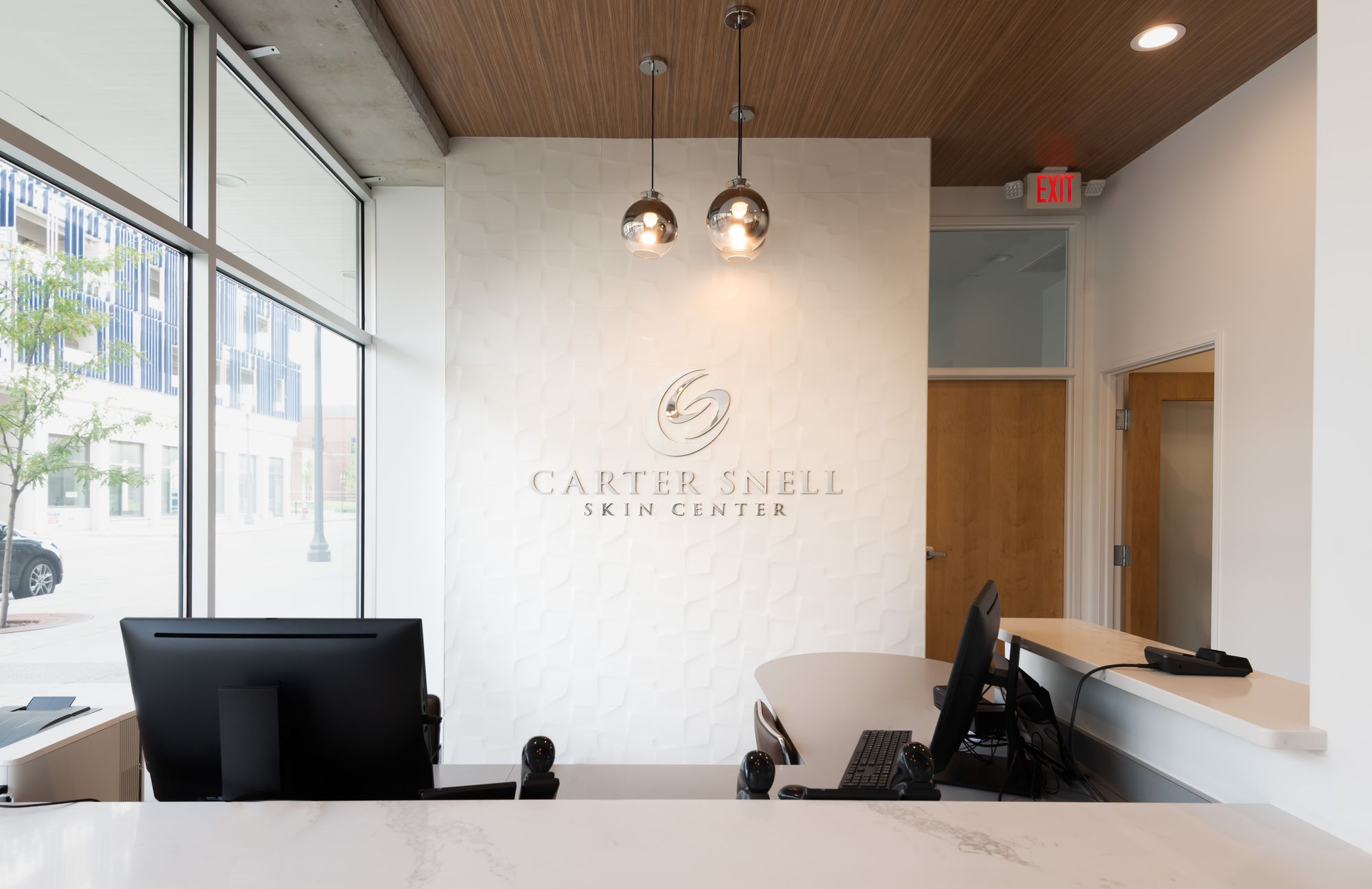 Carter Snell Skin Center sign, reception desk, and pendant lights inside the completed buildout